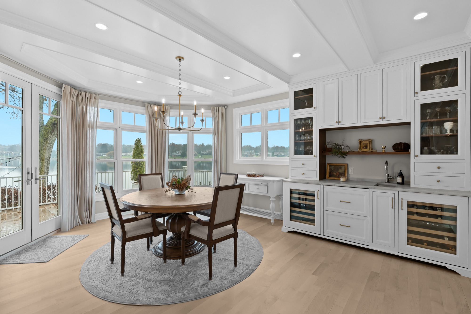 White built-in bar with wine refrigerators overlooking the lake