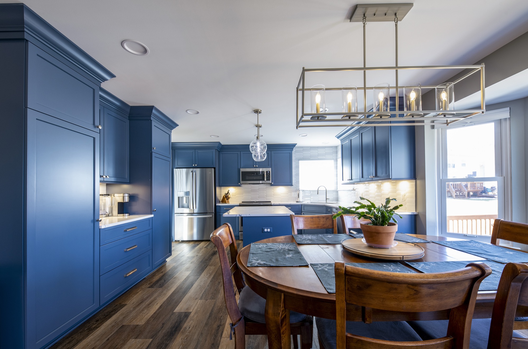 Deep blue custom kitchen open to a dining area