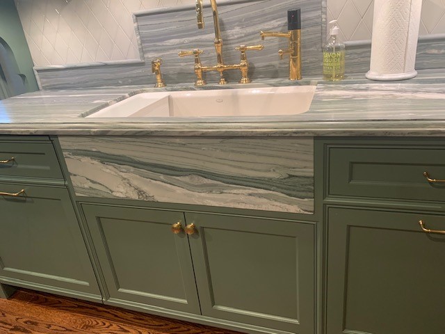Sage green vanity with marble slab front detail